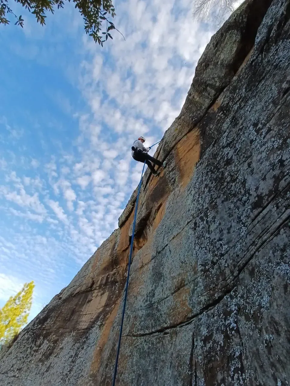 Abseiler descending the koppie cliff face